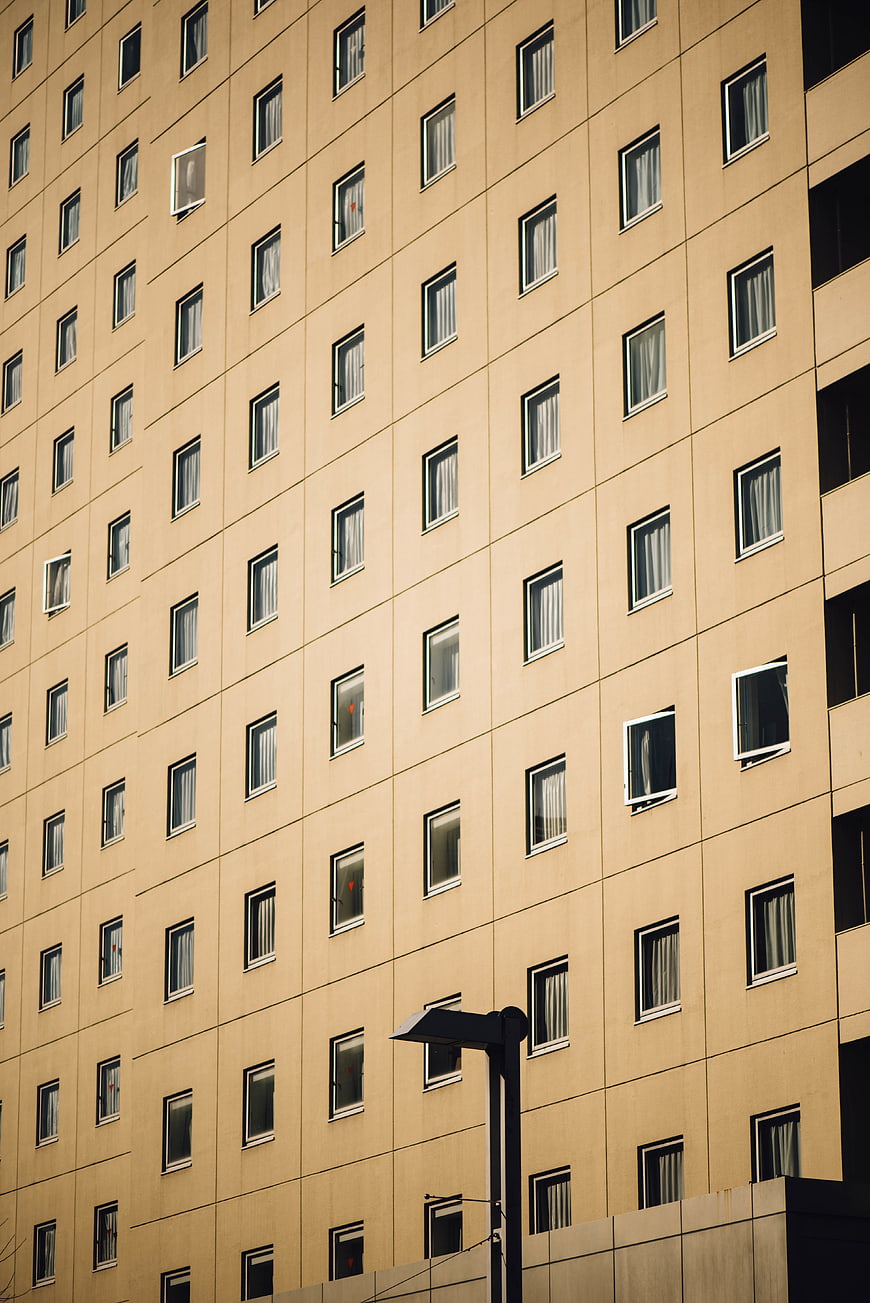 Modern beige apartment building facade with grid of windows