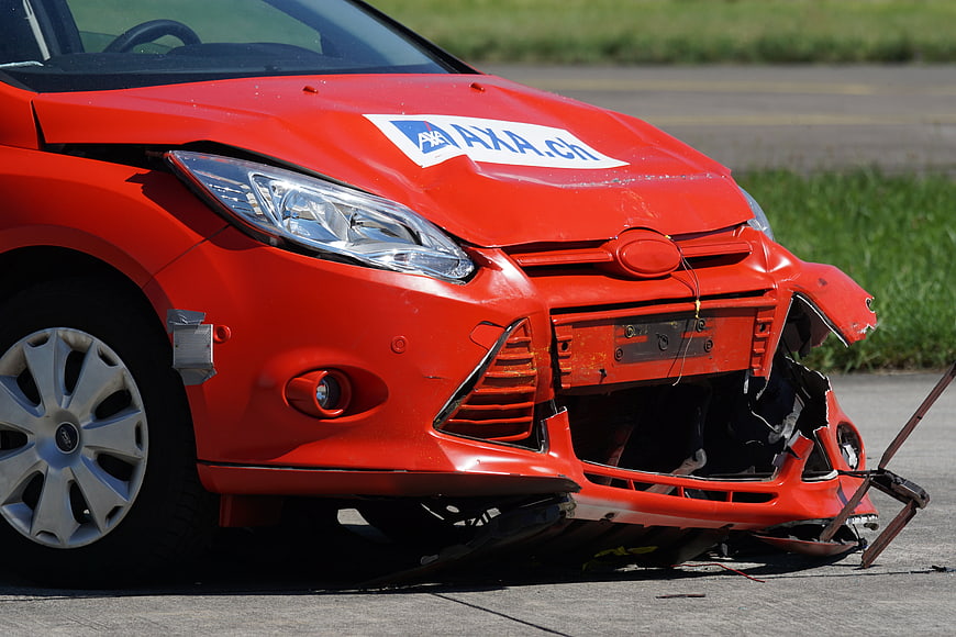 Damaged red car front bumper after crash test