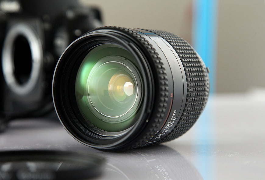 Close-up of a Nikon 35-105mm camera lens with green glass reflections