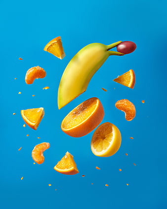 Fresh banana and citrus fruits floating on blue background