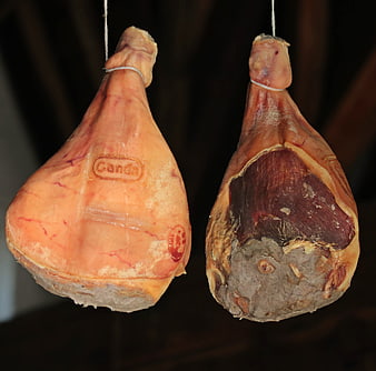 Two Hanging Dried Cured Hams in Traditional Aging Room