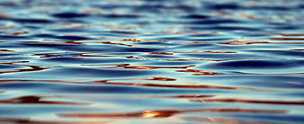 Abstract Blue Water Surface with Golden Reflections