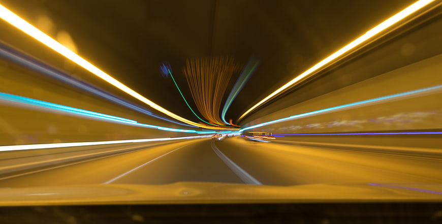 Abstract light trails speeding through a tunnel at night