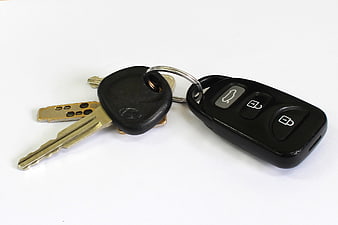 Black Car Key Fob And Metal Keys On White Background