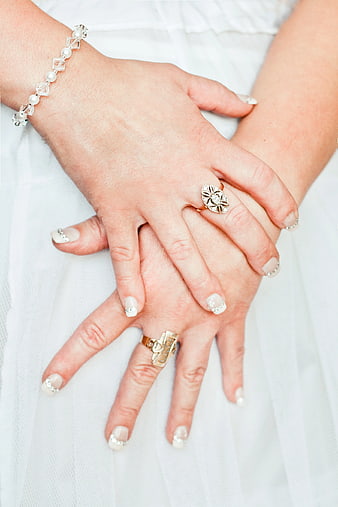 Close-up of female hands with diamond rings and pearl bracelet