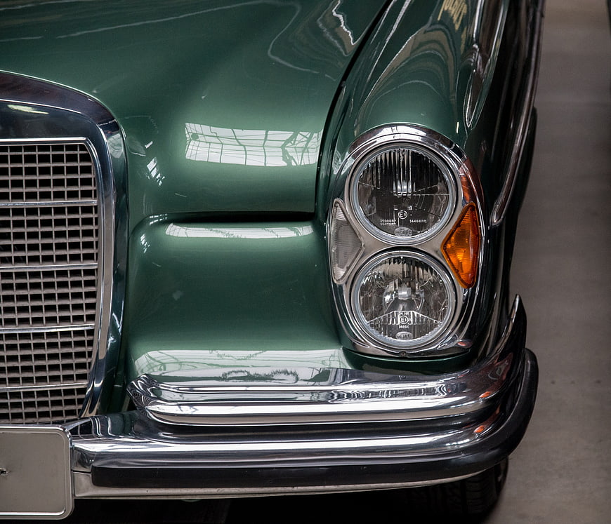 Close-up of Classic Green Mercedes-Benz Headlights and Chrome Bumper