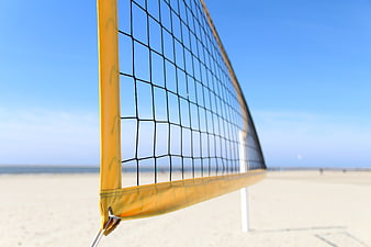 Close-up of yellow beach volleyball net on sandy shore