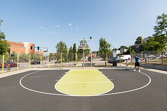 Young man shooting basketball on outdoor urban court