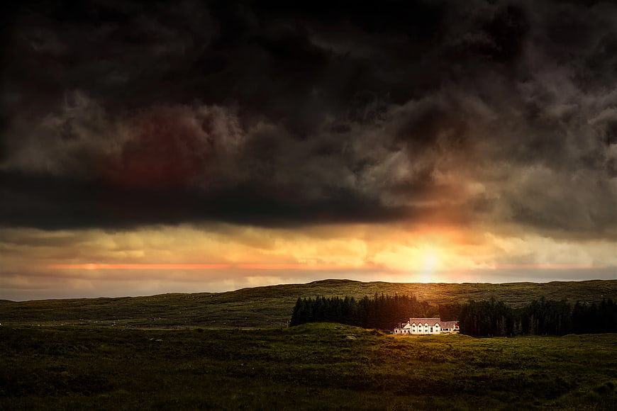 Dramatic Stormy Sky Over Isolated House in Green Landscape
