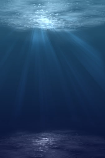 Deep blue underwater scene with sunbeams and ocean floor