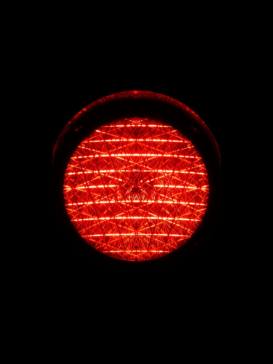 Close-up of glowing red traffic light lens at night