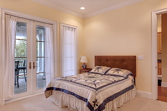 Cozy Bedroom with Quilt and French Doors to Deck
