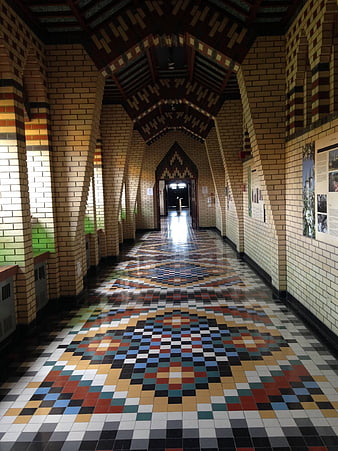 Colorful tiled floor in a historic brick cloister hallway