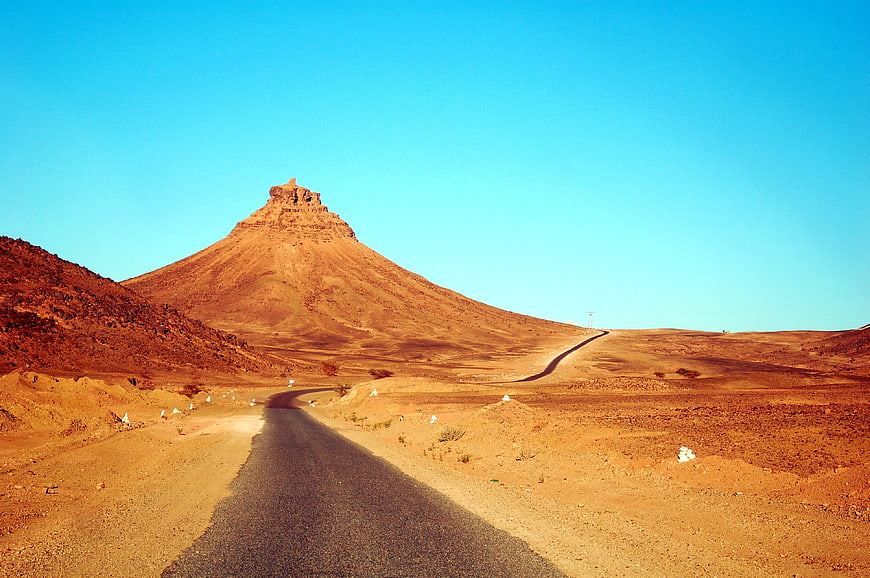 Desert Highway Leading To Majestic Mountain Peak In Morocco
