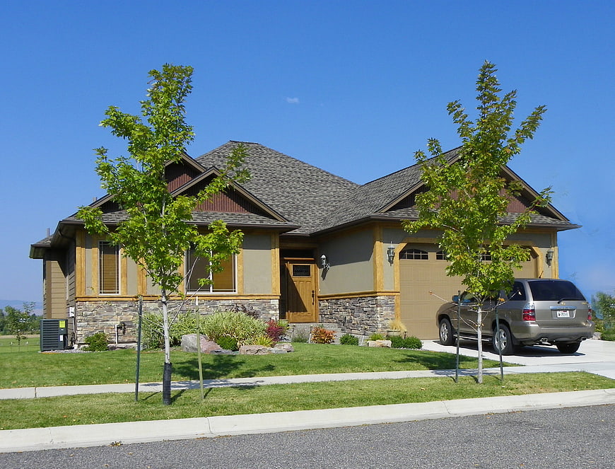 Suburban Single Family Home With Stone Facade And Landscaped Front Yard