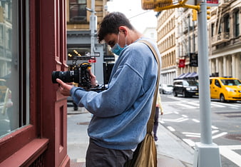 Cameraman filming on city street with professional camera