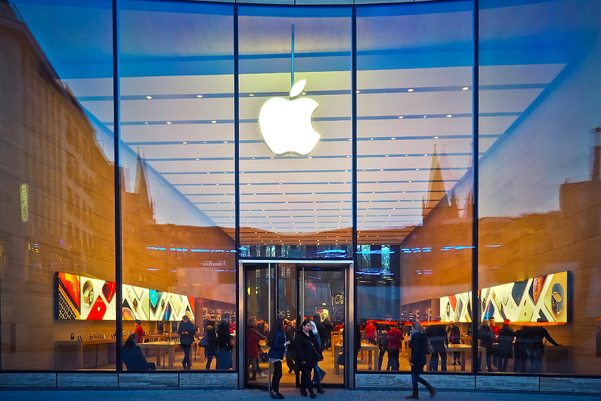 Apple Store Facade At Night With Glowing Logo And Glass Reflections
