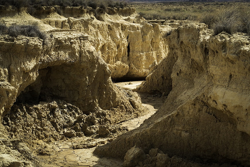 Eroded desert canyon landscape with dry cracked earth