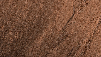 Close-up of textured brown stone surface with natural cracks