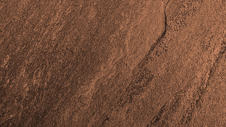 Close-up of textured brown stone surface with natural cracks