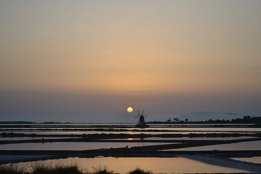 Silhouette of Windmill at Sunset Over Salt Pans