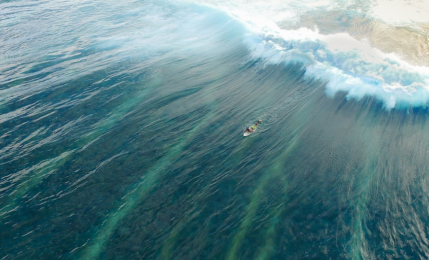 Aerial View of Surfer Riding a Massive Ocean Wave