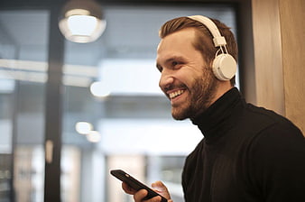 Happy Man Listening to Music with Headphones in Office