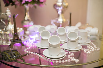 Elegant White Espresso Cups on Glass Table with Pearls and Eiffel Tower