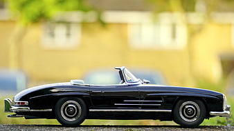Black Vintage Convertible Toy Car Model on Stone Surface