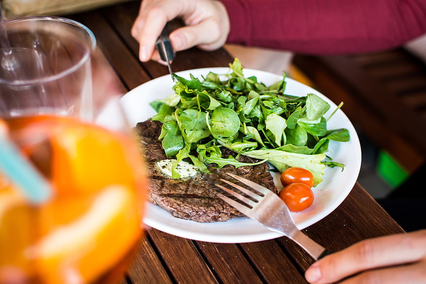 Grilled steak with fresh salad on wooden table