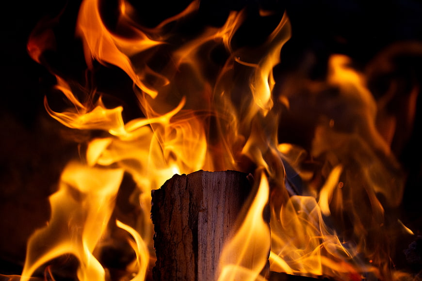 Close-up of burning wood log with bright orange flames