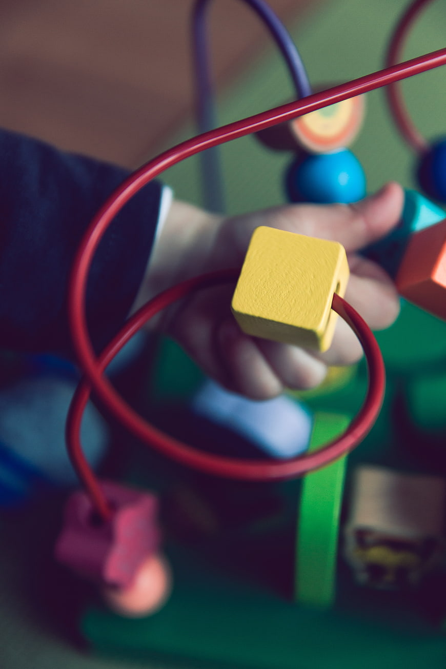 Child Playing with Wooden Bead Maze Toy