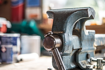 Close-up of a vintage metal bench vise in a workshop