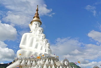 Five White Buddha Statues Against Blue Sky in Thailand