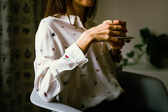 Woman in Patterned Blouse Holding Coffee Cup