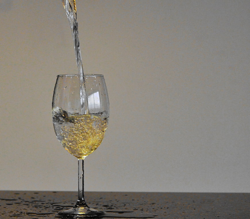 Pouring White Wine into Glass with Splash