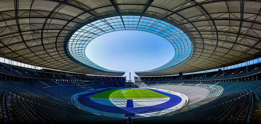 Panoramic view of empty modern stadium with blue seats and open roof