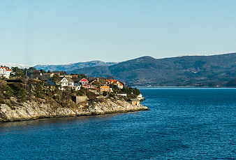 Colorful Coastal Houses on Rocky Shoreline with Blue Ocean