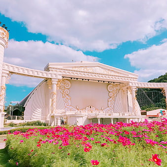 White ornate stage with pink cosmos flowers and blue sky