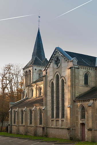 Sunlit Gothic Church with Spire and Contrails