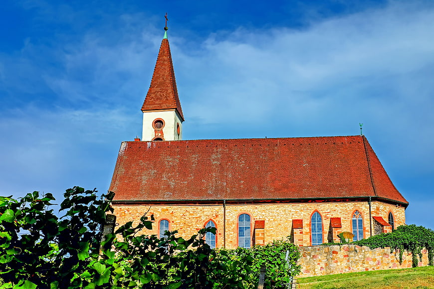 Historic Stone Church With Red Roof And Spire In Countryside