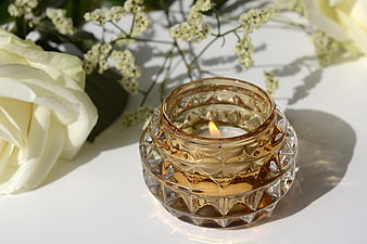 Amber glass candle holder with white rose and baby's breath