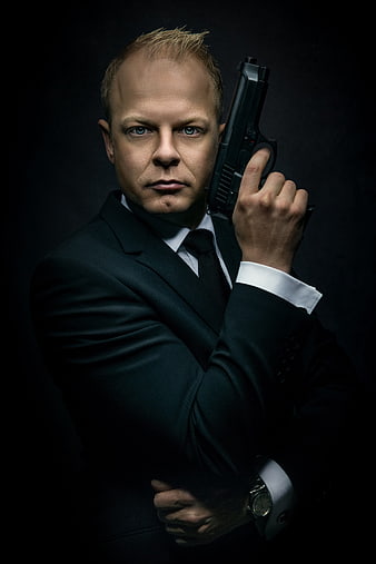 Dramatic Portrait of Man in Black Suit Holding Pistol