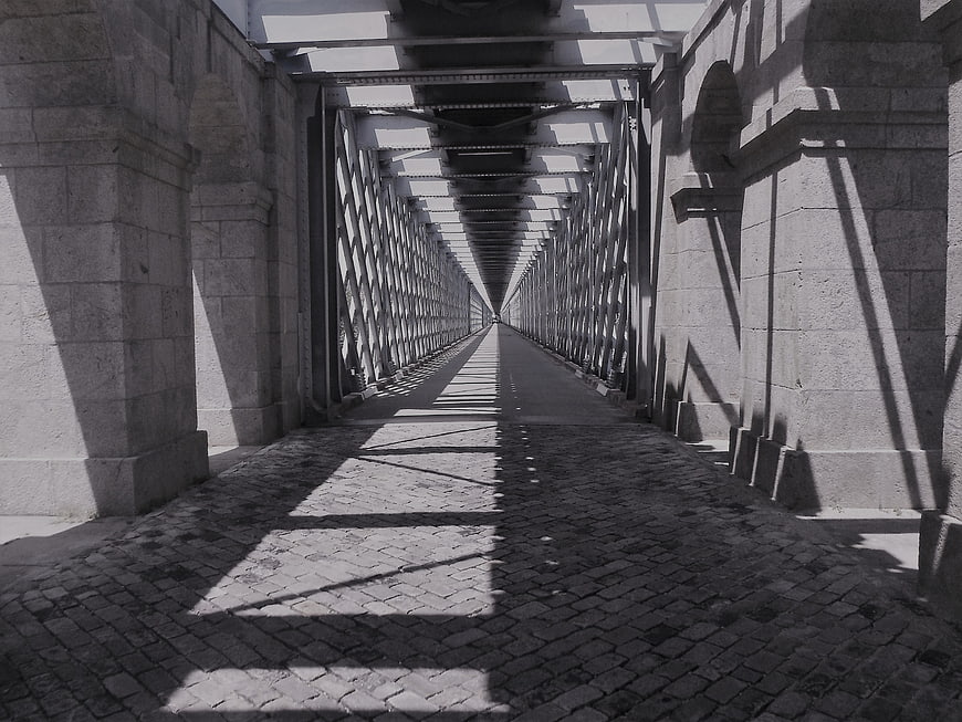 Black and white perspective of cobblestone bridge walkway