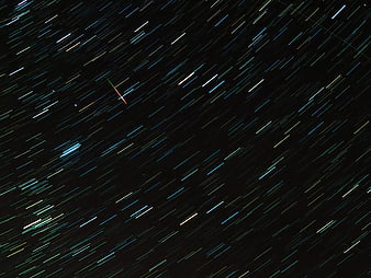 Diagonal Star Trails And Meteor Streaks In Dark Night Sky