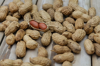 Peanuts in shells on rustic wooden table background