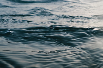 Close-up of dark blue ocean water ripples and bubbles