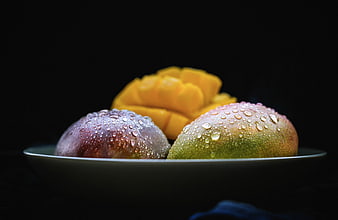 Fresh Mangoes with Water Droplets on Dark Background