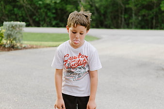 Young boy sticking tongue out on suburban street