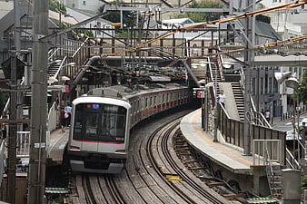 Japanese commuter train arriving at elevated station platform